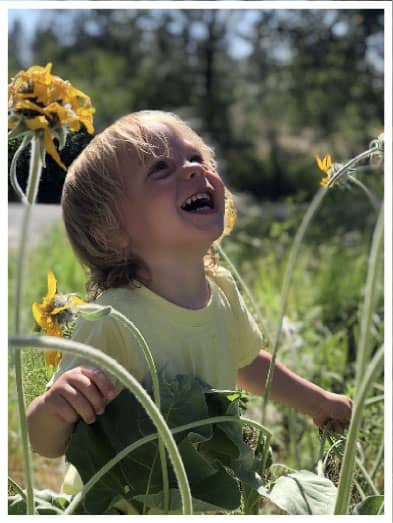 child playing in a field of flowers